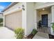 Inviting home exterior with a blue front door, outdoor seating, and a charming two-car garage at 7405 French Marigold Ave, Tampa, FL 33619