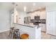 Stylish kitchen featuring stainless steel appliances, bar seating, and bright pendant lighting fixtures at 7405 French Marigold Ave, Tampa, FL 33619