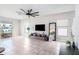 Open-concept living room featuring neutral walls, a ceiling fan, and plenty of natural light from large windows at 7405 French Marigold Ave, Tampa, FL 33619