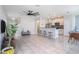 Open living space seamlessly connects to a modern kitchen with stainless steel appliances and a breakfast bar at 7405 French Marigold Ave, Tampa, FL 33619