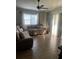 Sunlit living room features a comfortable sectional sofa, a ceiling fan, and tile flooring at 7719 Carriage Pointe Dr, Gibsonton, FL 33534
