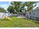 Large, fenced backyard with a play set, screened in porch and a table with chairs at 8897 54Th N St, Pinellas Park, FL 33782