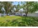 Exterior backyard view of home featuring green grass, a playset, screened-in porch, and privacy fence at 8897 54Th N St, Pinellas Park, FL 33782