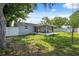 Backyard view with trees, green grass, a playset, privacy fence, and screened-in porch at 8897 54Th N St, Pinellas Park, FL 33782