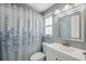 Full bath with a turtle-themed shower curtain, a white sink and vanity, and decorative mirror at 8897 54Th N St, Pinellas Park, FL 33782