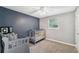 Bedroom room with a gray crib, changing table, ceiling fan, and a dark blue accent wall at 8897 54Th N St, Pinellas Park, FL 33782