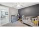 View of the bedroom area with gray carpet, crib, dresser, and view into the hallway at 8897 54Th N St, Pinellas Park, FL 33782
