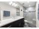 Bathroom featuring quartz counters, vanity with storage, and a glass-enclosed shower with a built-in seat at 9105 Camino Villa Blvd, Tampa, FL 33635