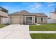 Well-kept single-story home boasting a clean driveway, attached garage, and lush front yard at 9105 Camino Villa Blvd, Tampa, FL 33635