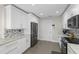 The kitchen has white cabinets, gray appliances, stone countertops and tile backsplash at 9105 Camino Villa Blvd, Tampa, FL 33635