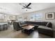 Bright living room with a large sectional sofa, modern ceiling fan, and an open layout connecting to the dining area at 9105 Camino Villa Blvd, Tampa, FL 33635