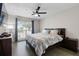Bedroom with a dark wood bed frame, ceiling fan, and window with curtains at 9105 Camino Villa Blvd, Tampa, FL 33635