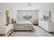 Large, bright bedroom with a window, chair, side table, and decorative lamps at 9107 Rally Spring Loop, Wesley Chapel, FL 33545