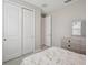 Bright bedroom featuring double sliding door closet and neutral decor at 9107 Rally Spring Loop, Wesley Chapel, FL 33545