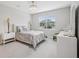 Serene bedroom featuring neutral colors, plush carpeting, and a large window with a view of the outdoors at 9107 Rally Spring Loop, Wesley Chapel, FL 33545