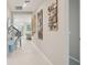 Bright hallway with neutral walls and modern art decorations leading to a living space at 9107 Rally Spring Loop, Wesley Chapel, FL 33545