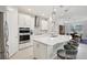 Kitchen with an island, seating, and stainless steel appliances at 9107 Rally Spring Loop, Wesley Chapel, FL 33545