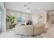 Bright living room featuring a curved sofa, large TV, and stylish bar area at 9107 Rally Spring Loop, Wesley Chapel, FL 33545