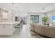 Open-concept living space with a kitchen, dining area, and living room with access to the outdoor pool area at 9107 Rally Spring Loop, Wesley Chapel, FL 33545