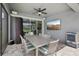 Stylish outdoor patio with a ceiling fan, wall-mounted TV, and comfortable seating area at 9107 Rally Spring Loop, Wesley Chapel, FL 33545