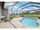 Screened-in lanai with a pool, patio furniture, and an outdoor kitchen, overlooking the backyard at 9107 Rally Spring Loop, Wesley Chapel, FL 33545
