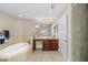 Spacious bathroom featuring a corner bathtub, vanity area with mirrors, and a tiled shower at 10002 Key Haven Rd # 503, Seminole, FL 33777