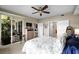 Bright bedroom featuring a ceiling fan, sliding glass doors to a deck, and an adjacent bathroom at 10002 Key Haven Rd # 503, Seminole, FL 33777