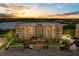 Exterior view of the residence complex with parking, palm trees, and a beautiful sunset backdrop at 10002 Key Haven Rd # 503, Seminole, FL 33777
