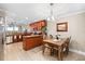 Open concept kitchen featuring wooden cabinetry, granite countertops, stainless steel appliances, and a dining table at 10002 Key Haven Rd # 503, Seminole, FL 33777