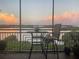 Serene screened lanai with table and chair overlooking the water, ideal for enjoying peaceful sunsets at 10002 Key Haven Rd # 503, Seminole, FL 33777