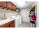 Laundry room featuring wooden cabinetry, front loading washing machines, and storage at 10002 Key Haven Rd # 503, Seminole, FL 33777