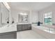 Spacious bathroom featuring a soaking tub, large window, and a gray double vanity at 101 Bandera Ne Way, St Petersburg, FL 33704