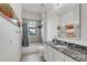 Bright bathroom featuring a tub/shower combo, black granite countertop, and a decorative mirror at 101 Bandera Ne Way, St Petersburg, FL 33704