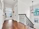 Hallway with hardwood floors, white walls, and wrought iron staircase railing at 101 Bandera Ne Way, St Petersburg, FL 33704
