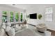 Bright living room with a modern sofa, hardwood floors, and multiple windows for natural light at 101 Bandera Ne Way, St Petersburg, FL 33704