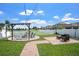Landscaped backyard with pergola, hammock, string lights, and a view of the pond at 10624 Aldo Moro Dr, Wimauma, FL 33598