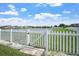 Beautiful lake view from backyard through white picket fence, adds a charming touch to the property at 10624 Aldo Moro Dr, Wimauma, FL 33598