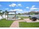 Beautiful backyard with pergola, hammock, pond, firepit, and string lights at 10624 Aldo Moro Dr, Wimauma, FL 33598