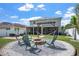 Inviting backyard with fire pit, outdoor seating, and covered patio perfect for relaxation and entertaining at 10624 Aldo Moro Dr, Wimauma, FL 33598