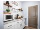 A cozy coffee bar featuring white cabinetry, granite countertops, and shiplap walls at 10624 Aldo Moro Dr, Wimauma, FL 33598