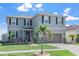 Inviting two-story home with a lush green lawn and mature palm trees in the front yard at 10624 Aldo Moro Dr, Wimauma, FL 33598