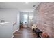Hallway with wood-look floors, leading to an accent brick wall, adding texture and character to the space at 10624 Aldo Moro Dr, Wimauma, FL 33598