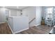 Hallway with wood-look flooring and neutral paint, offering a bright and welcoming transition space at 10624 Aldo Moro Dr, Wimauma, FL 33598