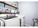 Well-organized laundry room with shelving, modern washer and dryer units at 10624 Aldo Moro Dr, Wimauma, FL 33598