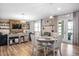 Open-concept living area adjacent to the dining area with wood floors and ample natural light at 10624 Aldo Moro Dr, Wimauma, FL 33598