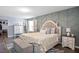 This main bedroom features a stylish geometric accent wall, adding depth and a modern touch to the design at 10624 Aldo Moro Dr, Wimauma, FL 33598