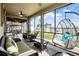 Relaxing screened-in patio with hanging swing chairs and comfortable seating area at 10624 Aldo Moro Dr, Wimauma, FL 33598