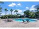 Community pool with lounge chairs and palm trees, offering a refreshing outdoor space for residents at 10624 Aldo Moro Dr, Wimauma, FL 33598