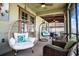 Charming covered porch featuring a hanging swing chair and comfortable seating at 10624 Aldo Moro Dr, Wimauma, FL 33598