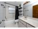 Cozy bathroom showcasing a shower-tub combo, modern vanity with a white sink, and stylish black fixtures at 11203 Egret Nest Ct, Riverview, FL 33569